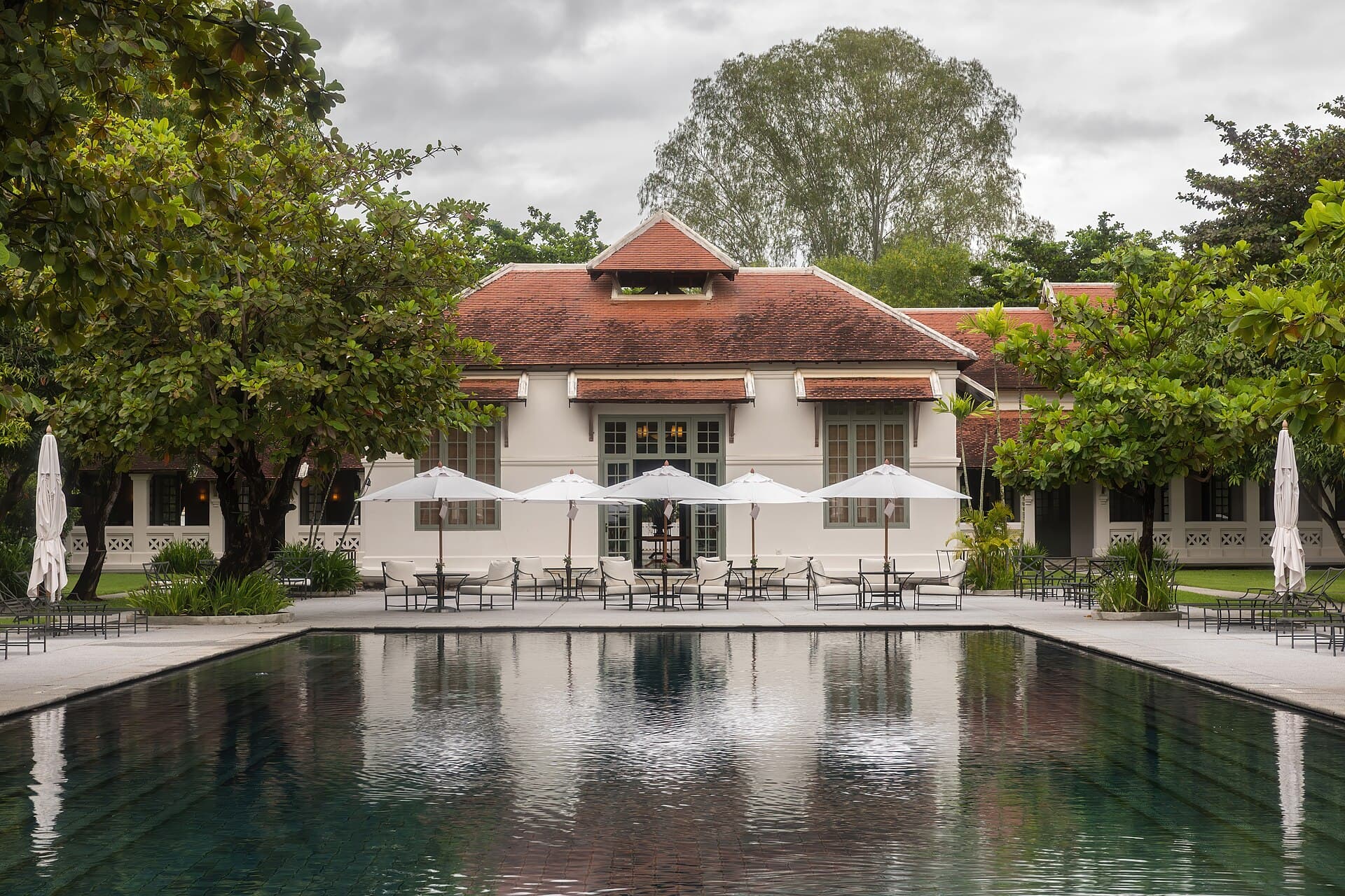 Hotel building and pool terrace surrounded by trees