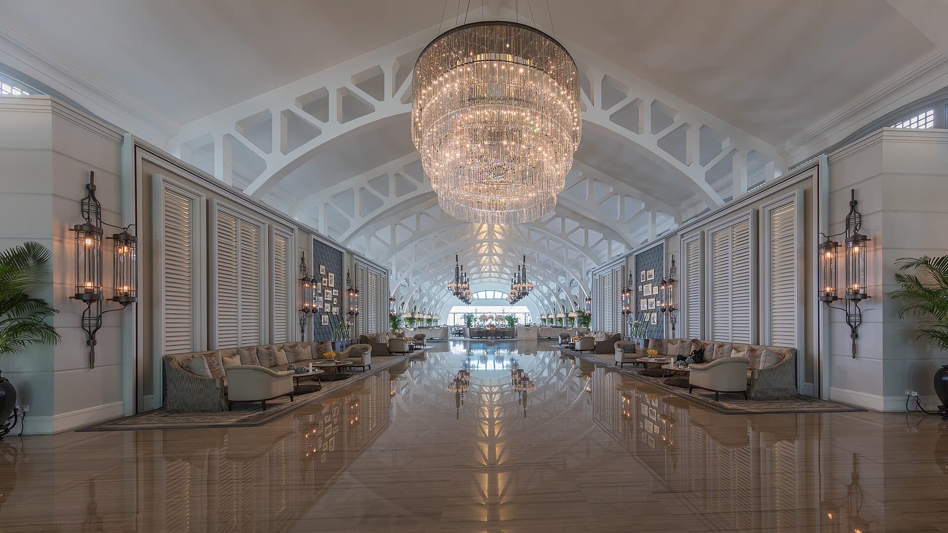 Grand hotel lobby hall with a chandelier and seating areas