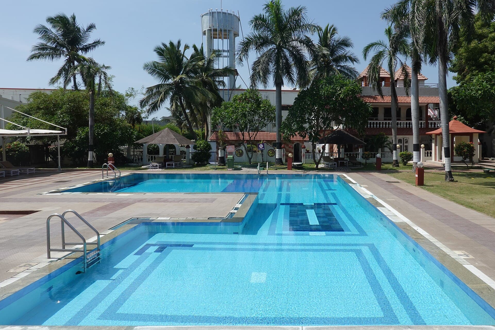 Resort swimming pool lined with palm trees